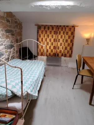 a bedroom with a bed and a desk and a table at Jolie maison vintage, à 15mn de Lagrasse in Taurize