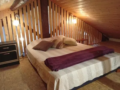 a bedroom with a bed in a wooden cabin at Appartement prémian in Prémian