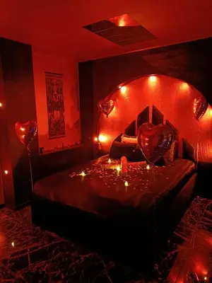 a red room with a bed with a heart on it at Les cités romances Le Cléopâtre in Carcassonne