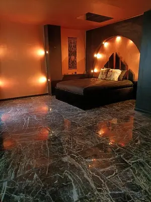 a bedroom with a bed and a marble floor at Les cités romances Le Cléopâtre in Carcassonne