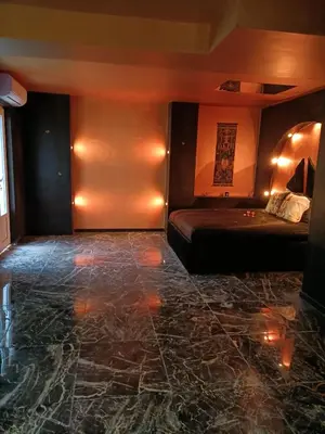 a room with a bed and a stone floor at Les cités romances Le Cléopâtre in Carcassonne