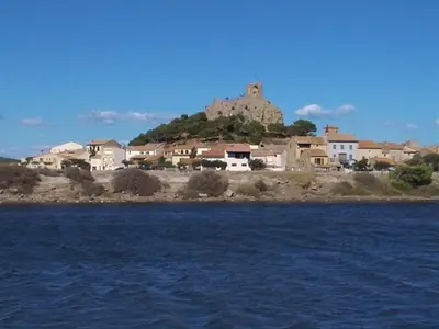 a town with a castle on top of a hill at Studio rénové centre Gruissan - 2 pers, parking privé - FR-1-796-92 in Gruissan