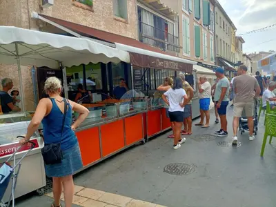 a group of people walking around a food stand at Studio rénové centre Gruissan - 2 pers, parking privé - FR-1-796-92 in Gruissan