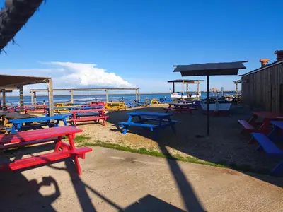 a group of picnic tables in front of the ocean at Studio rénové centre Gruissan - 2 pers, parking privé - FR-1-796-92 in Gruissan