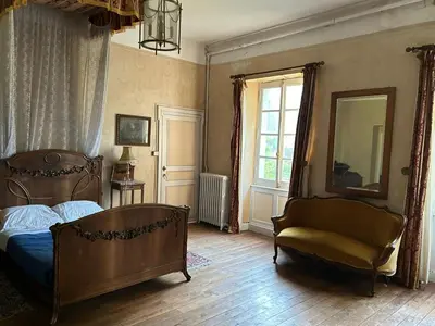 a bedroom with a bed and a chair and a window at chateaubelleauboisdormant in Cambounet-sur-le-Sor