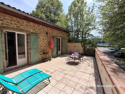 a patio with a blue bench and a table and chairs at Gites Villa Robinson in Mazamet