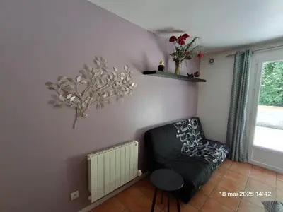 a living room with a black couch and a window at Gites Villa Robinson in Mazamet