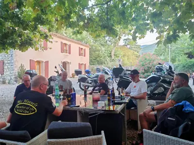 a group of people sitting around a table with motorcycles at Relais de Laval in Caudiès-de-Fenouillèdes