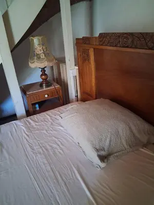 a bedroom with a bed and a table with a lamp at - Atelier - in Villalier