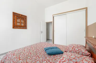 a bedroom with a bed with a blue pillow on it at Le Parc de la Révolution - Proche Gare in Narbonne