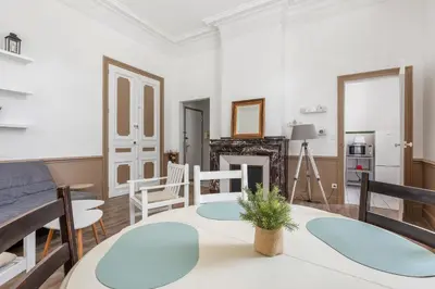 a living room with a table and a fireplace at Le Parc de la Révolution - Proche Gare in Narbonne