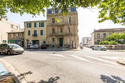 an empty street with cars parked in front of a building at Le Parc de la Révolution - Proche Gare in Narbonne