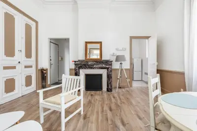a living room with a fireplace and a table and chairs at Le Parc de la Révolution - Proche Gare in Narbonne