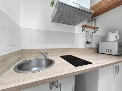 a kitchen counter with a sink and a microwave at Appartement Lumineux Carcassonne Centre in Carcassonne