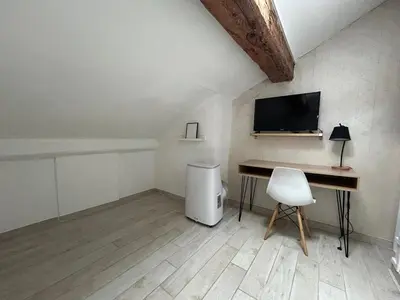 a room with a desk and a television and a chair at Appartement Lumineux Carcassonne Centre in Carcassonne