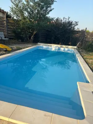 a large blue swimming pool in a yard at Villa avec piscine à mirepoix in Mirepoix