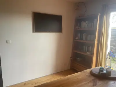 a living room with a tv and a book shelf at Villa avec piscine à mirepoix in Mirepoix