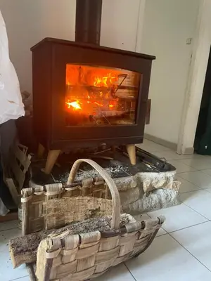 a woodburning stove in a room with a basket at Villa avec piscine à mirepoix in Mirepoix