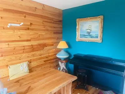 a room with a piano and a blue wall at Villa avec piscine à mirepoix in Mirepoix