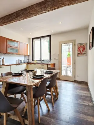 a kitchen and dining room with a wooden table and chairs at Maison 4 pers, calme et confort in Opoul-Périllos