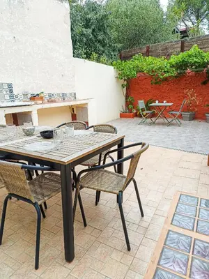 a wooden table and chairs on a patio at Maison 4 pers, calme et confort in Opoul-Périllos