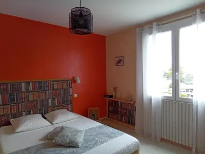 a bedroom with orange walls and a bed and a window at Chambre la Limouxine in Limoux