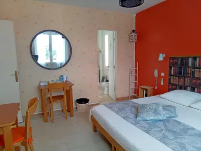 a bedroom with a bed and a table and a mirror at Chambre la Limouxine in Limoux