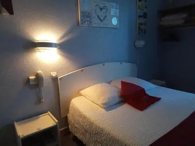 a small bedroom with a bed with red pillows at Chambre Love in Limoux