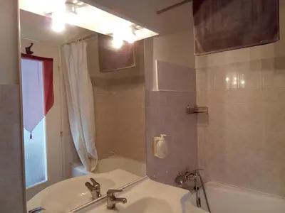 a bathroom with a sink and a tub and a mirror at Chambre Love in Limoux