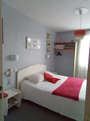 a bedroom with a white bed with a red blanket at Chambre Love in Limoux