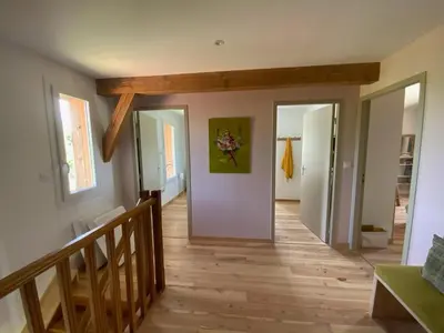 a hallway with wooden floors and a staircase with doors at En joia ! in Teyssode