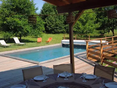 a swimming pool with chairs and a table and a tableasteryasteryasteryasteryastery at En joia ! in Teyssode