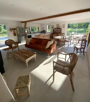 a living room with a couch and a table and chairs at En joia ! in Teyssode