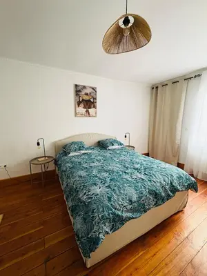 a bedroom with a bed with a blue comforter at Le Toit Terrasse l 2 chambres l Terrasse in Castres