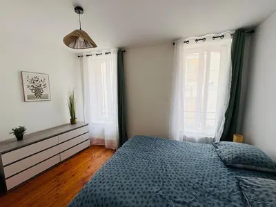 a bedroom with a blue bed and two windows at Le Toit Terrasse l 2 chambres l Terrasse in Castres