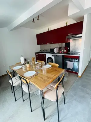 a kitchen with a wooden table and some chairs at Le Toit Terrasse l 2 chambres l Terrasse in Castres