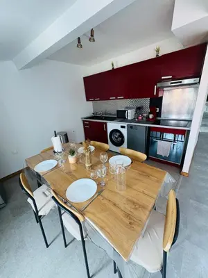 a kitchen with a wooden table and some chairs at Le Toit Terrasse l 2 chambres l Terrasse in Castres