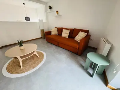a living room with a couch and a table at Le Toit Terrasse l 2 chambres l Terrasse in Castres