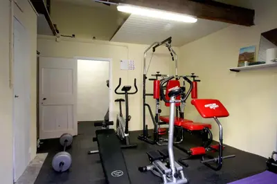 a room with a gym with a bike and weights at Maison de maître à BRAM # Jacuzzi in Bram