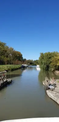 a river with boats parked on the side of it at Maison de maître à BRAM # Jacuzzi in Bram