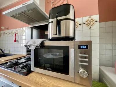 a microwave oven sitting on top of a kitchen counter at Le Strasbourg - 3 chambres - parking et terrasse in Carcassonne