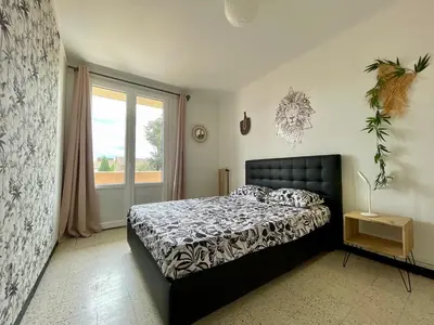 a bedroom with a bed and a window at Le Strasbourg - 3 chambres - parking et terrasse in Carcassonne
