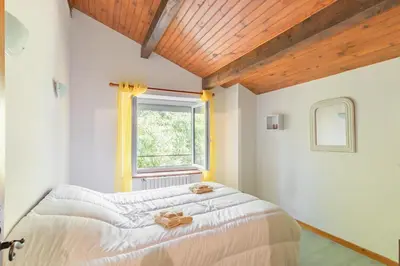 a bedroom with a bed and a window at La Pause Verte - 30min de Castre in Montredon-Labessonnié