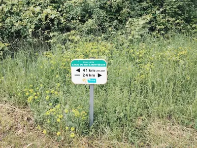 a sign on the side of a rocky road at Les Chambres Postales - Halte Ressourçante Occitanie in Bellegarde-du-Razès