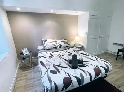 a bedroom with a bed with a black and white comforter at Appartement avec Patio in Carcassonne
