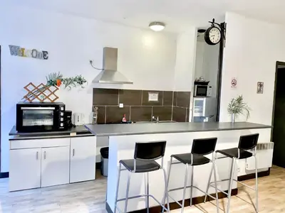 a kitchen with a counter and four bar stools at Appartement avec Patio in Carcassonne