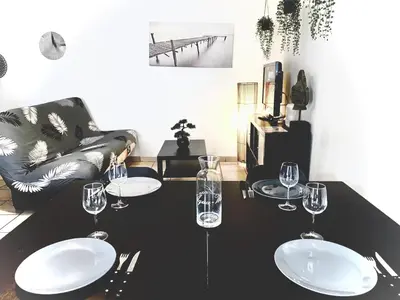 a black table with wine glasses and a couch at Appartement Centre Ville in Carcassonne