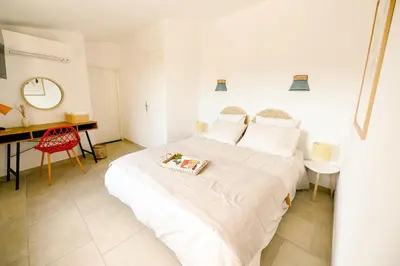 a white bedroom with a white bed and a desk at Maison La Djoon,Vue Cité, centre ville Spa Jardin in Carcassonne