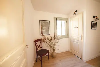 a room with a chair and a window and a vase at Maison La Djoon,Vue Cité, centre ville Spa Jardin in Carcassonne