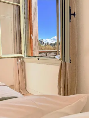 a bedroom with a bed and a window with a view at Maison La Djoon,Vue Cité, centre ville Spa Jardin in Carcassonne
